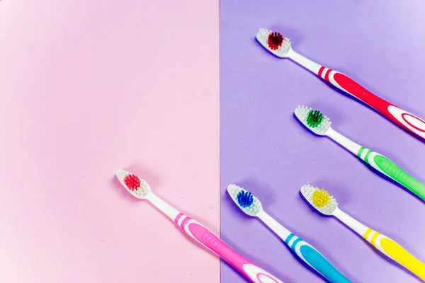 Cepillos de dientes y una pasta de dientes sobre un fondo colorido — Foto de Stock