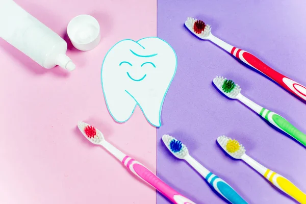 Brosses à dents et un dentifrice sur un fond coloré — Photo