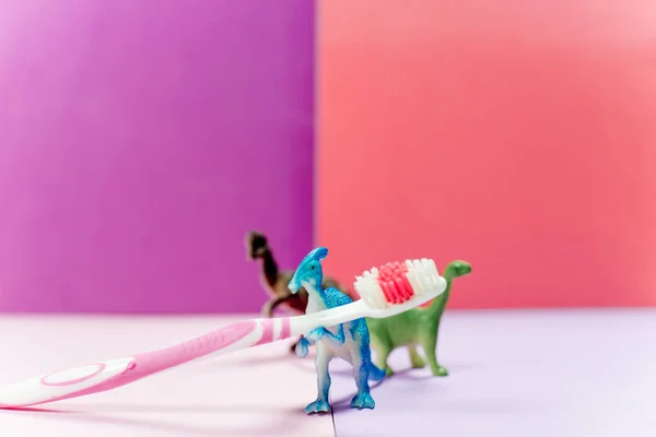 Escovas de dentes e uma pasta de dentes em um fundo colorido — Fotografia de Stock