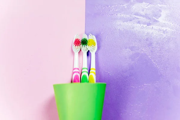 Cepillos de dientes y una pasta de dientes sobre un fondo colorido —  Fotos de Stock