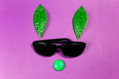 Yeşil bitki yaprakları ile serin siyah güneş gözlüğü