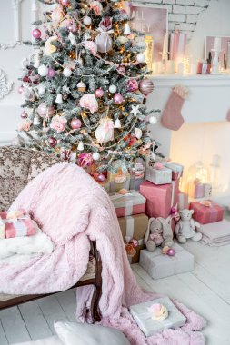 Noel ağacı olan ve altında hediyeler olan bir Noel salonu.