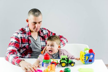 Baba ve yürümeye başlayan çocuk oğlu evde oynarken eğleniyor