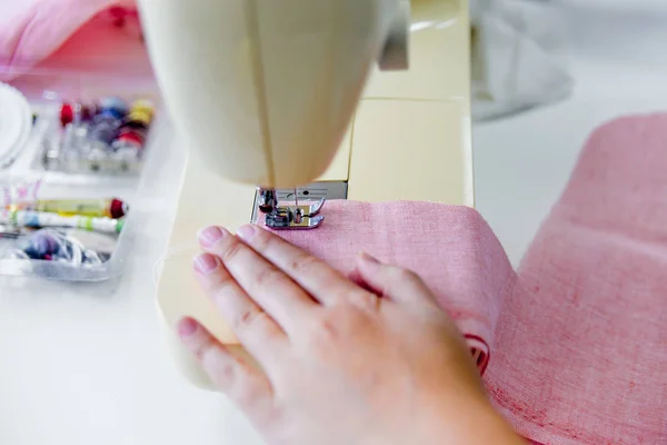 Manos femeninas están utilizando una máquina de coser — Foto de Stock