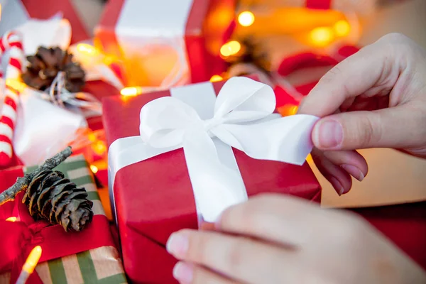 Manos femeninas envolviendo cajas de regalo de Navidad rojas —  Fotos de Stock