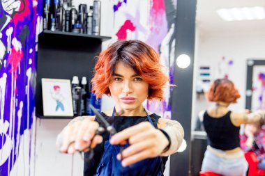 Profesyonel kuaför müşteriyle kuaförde çalışıyor.