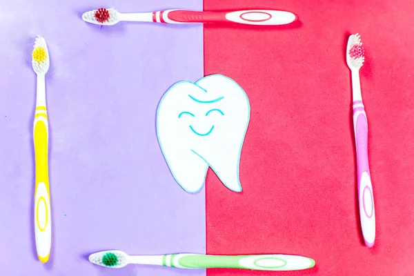 Brosses à dents et un dentifrice sur un fond coloré — Photo