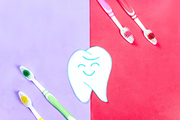 Brosses à dents et un dentifrice sur un fond coloré — Photo