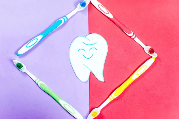 Brosses à dents et un dentifrice sur un fond coloré — Photo