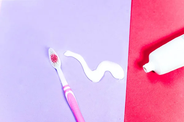 Toothbrushes and a toothpaste on a colorful background — Stock Photo, Image