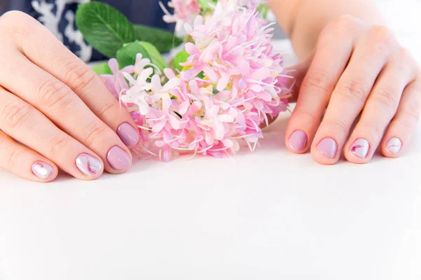 Cuidado de la piel de la mano femenina - manos sosteniendo flores —  Fotos de Stock