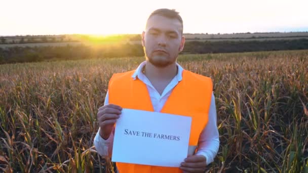 Pohled shora na zoufalého farmáře stojícího v obilí poškozeném suchem při západu slunce. — Stock video