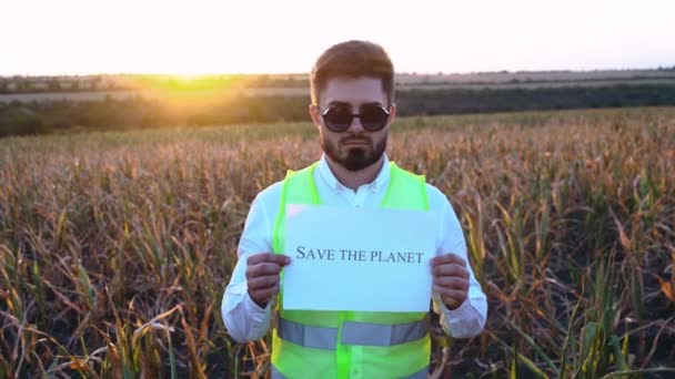 Portrét smutného mladého podnikatele držícího plaketu s nápisem Zachraňte tuto Zemi. — Stock video