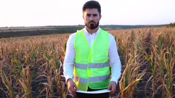 Porträtt av en sorglig karismatisk ung jordbrukare som innehar en plakett med inskriptionen Ingen solros 2020. — Stockvideo