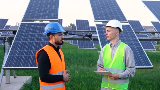 Два профессиональных белых инженера обсуждают план по установке новых солнечных панелей. — стоковое видео