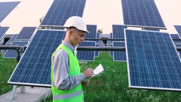 Um engenheiro verifica os painéis solares. — Vídeo de Stock