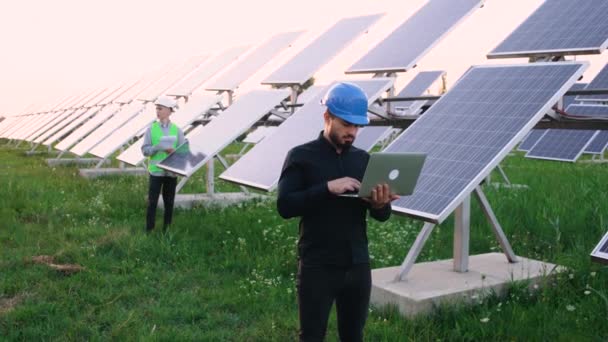 Chief Engineer utvecklar en plan för att utöka ett nytt nätverk av solpaneler på den bärbara datorn. — Stockvideo