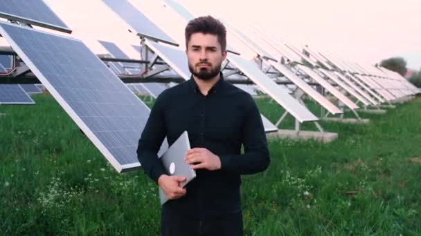 O retrato de um engenheiro chefe alegre no fundo do painel solar. — Vídeo de Stock