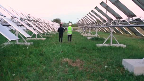 Veselý bělošský dělník s úspěšným inženýrem procházejícím se po solární farmě. — Stock video