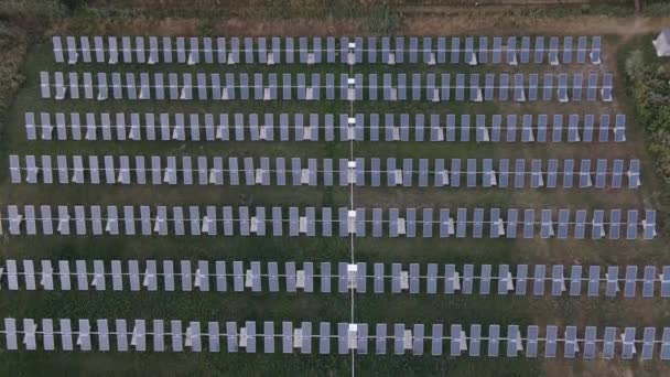 Planta de energía solar en el campo verde en un día soleado. Vista aérea. — Vídeos de Stock