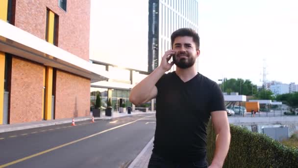 Gelukkige zakenman praten aan de telefoon tijdens het lopen — Stockvideo