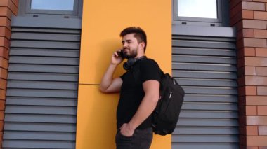 Gözlüklü, kulaklıklı, ceketli, sırt çantalı genç hippi..