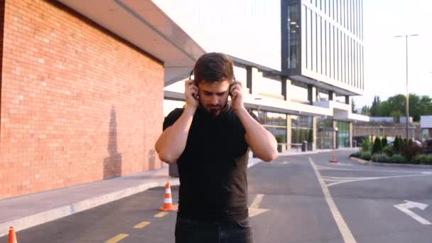 Gelukkige jongeman tijdens het luisteren naar zijn favoriete lied op zijn koptelefoon. — Stockvideo