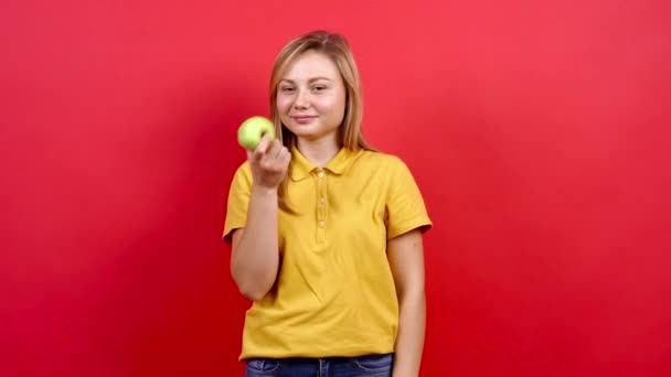 Tlustá a veselá blondýnka, která drží bílé jablko a doporučuje ho pro zdravý životní styl. — Stock video