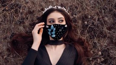 Çimlerin üzerinde yatan bir kızın videosu. Yüzünde çok güzel bir maske var..