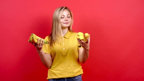 可爱和一个穿着黄色T恤的胖妞手里拿着很多香蕉. — 图库视频影像