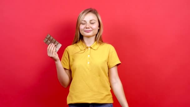 Blanke vrouw die chocolade eet in de studio — Stockvideo