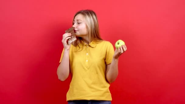 Linda y una niña gorda con una camiseta amarilla sostiene un chocolate en su mano, — Vídeo de stock