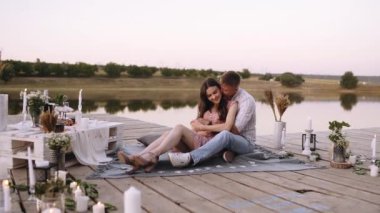 Romantik çift. Genç adam kız arkadaşını arkadan kucaklıyor ve onu öpüyor..