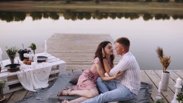 Romantiskt par omfamnar på ett trädäck mitt i en sjö. — Stockvideo