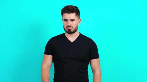 Geheimnisvoller junger Kaukasier in schwarzem T-Shirt, der dich auffordert, mit dem Finger auf den Lippen leise zu sein — Stockvideo