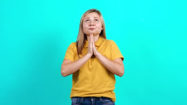 The young woman in suspense with her hands together looks up. — Stock Video