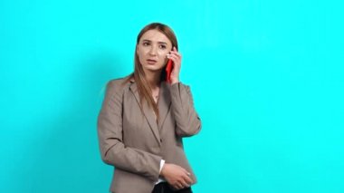 Kahverengi saçlı, iş tarzı ceketli neşeli ve arkadaş canlısı bir genç kadın.