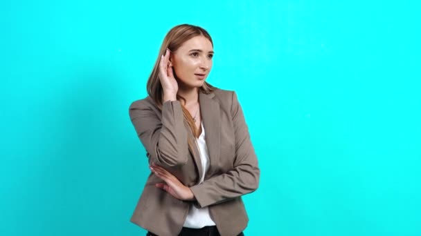 Nieuwsgierige, sluwe jonge vrouw in een jasje luisterend naar een privé gesprek — Stockvideo