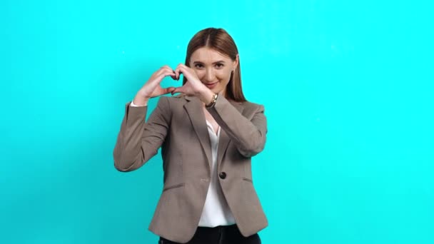 Generous young woman in business suit with wide smile showing heart gesture. — Stock Video