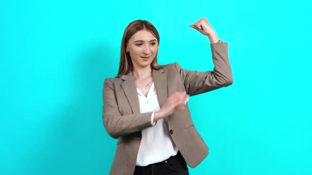 Mujer joven positiva y segura de sí misma en chaqueta elegante, mostrando los músculos del brazo — Vídeo de stock