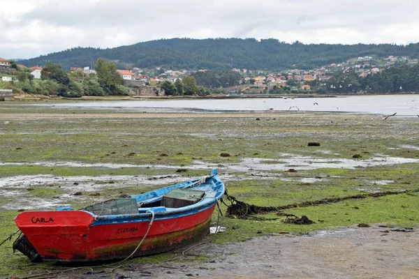 A red aground boat in the low tide