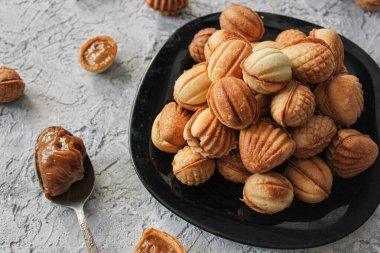Yoğunlaştırılmış sütlü fındıklar yakın plan, gri arka planda sağa kayıyor.
