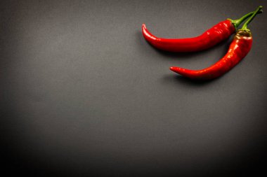 Siyah arka planda iki kırmızı biber.