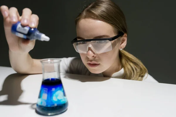 Lány vegyész a laboratóriumban végez egy kísérletet — Stock Fotó
