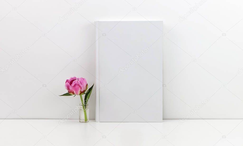 White book mockup with a pink peony flower