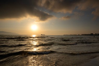 Römorkör gün batımında tankeri denize çekiyor.