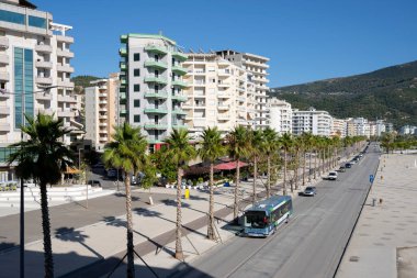 Asfalt yolu tatil köyünde palmiye ağaçlarıyla çevrili.