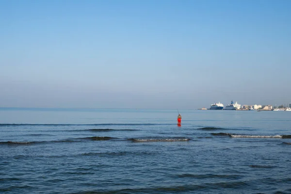 Pescatore in piedi sulla riva del mare aggancia un pesce contro l'alba. Spin Pesca hobby cattura di un pesce in spiaggia — Foto Stock