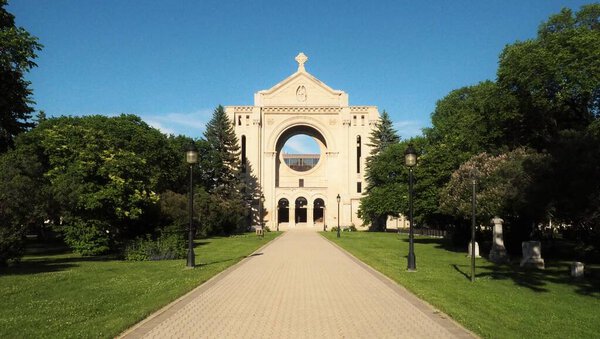 Saint Boniface Cathedral contrasted against a bright blue sky on a sunny day in Winnipeg, Manitoba, Canada.  This building serves as the principal church for Eastern Manitoba.