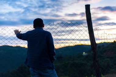 Guatemala dağları arasında gün doğumunu bekleyen bir adam.